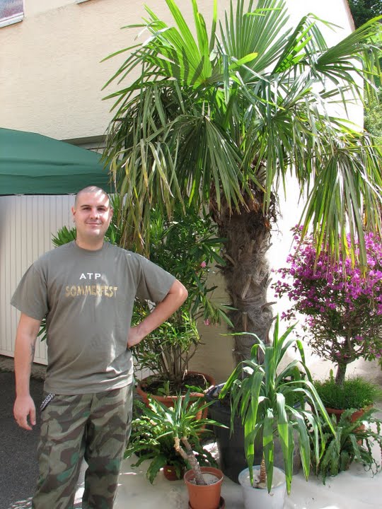 Andre steht stolz vor unserer Palmenlandschaft